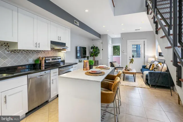 a kitchen with stainless steel appliances kitchen island granite countertop a sink and cabinets