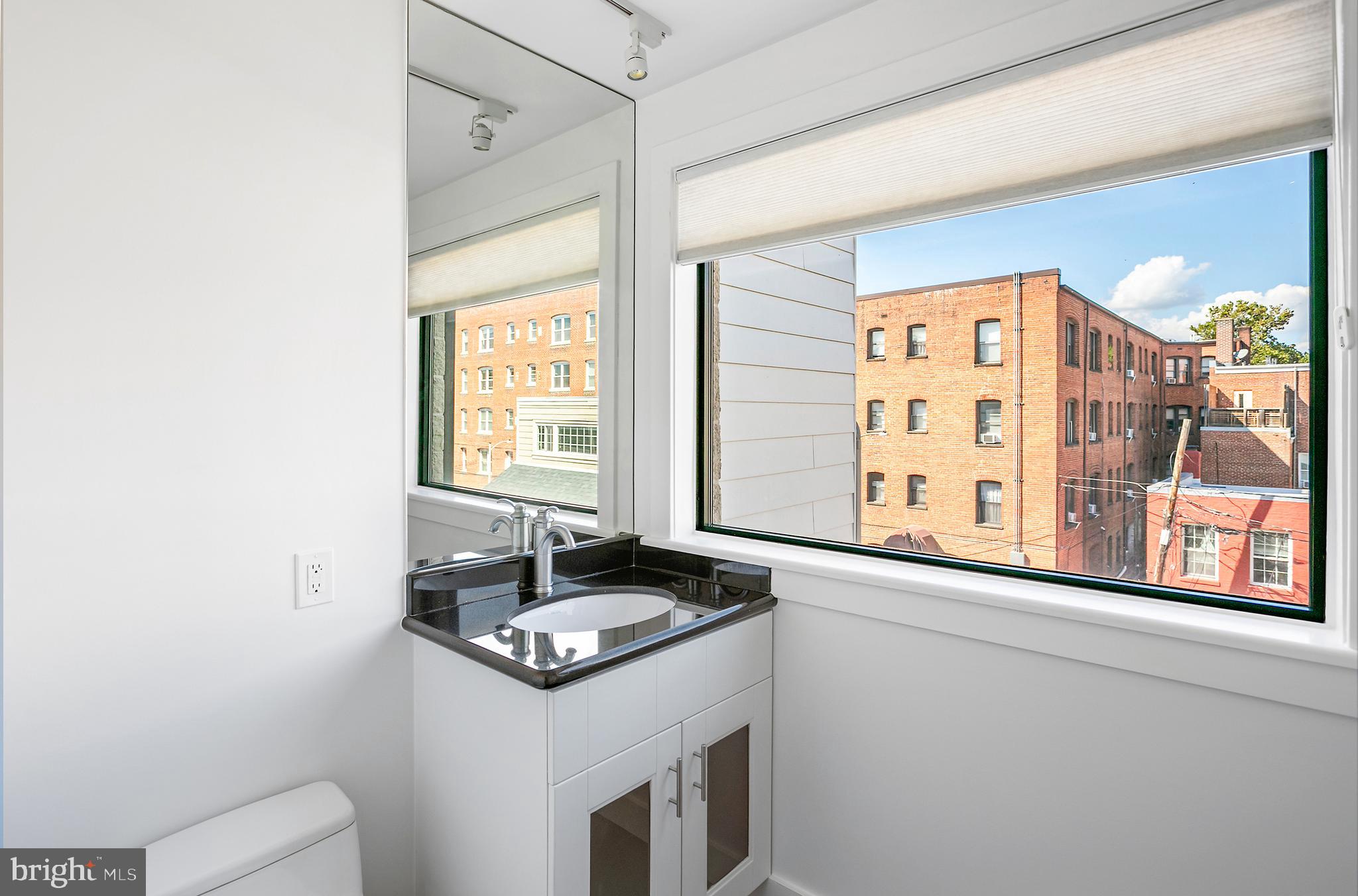 1461 Harvard Street Northwest, Unit 5 Washington, DC 20009 - Photo 14 of 33 a kitchen with a refrigerator and a window