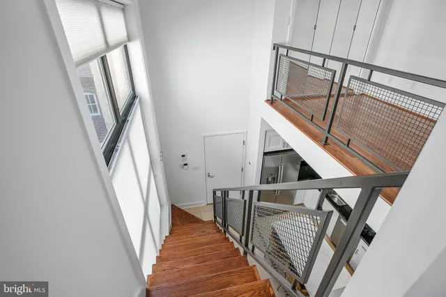 a view of staircase with white walls and railing