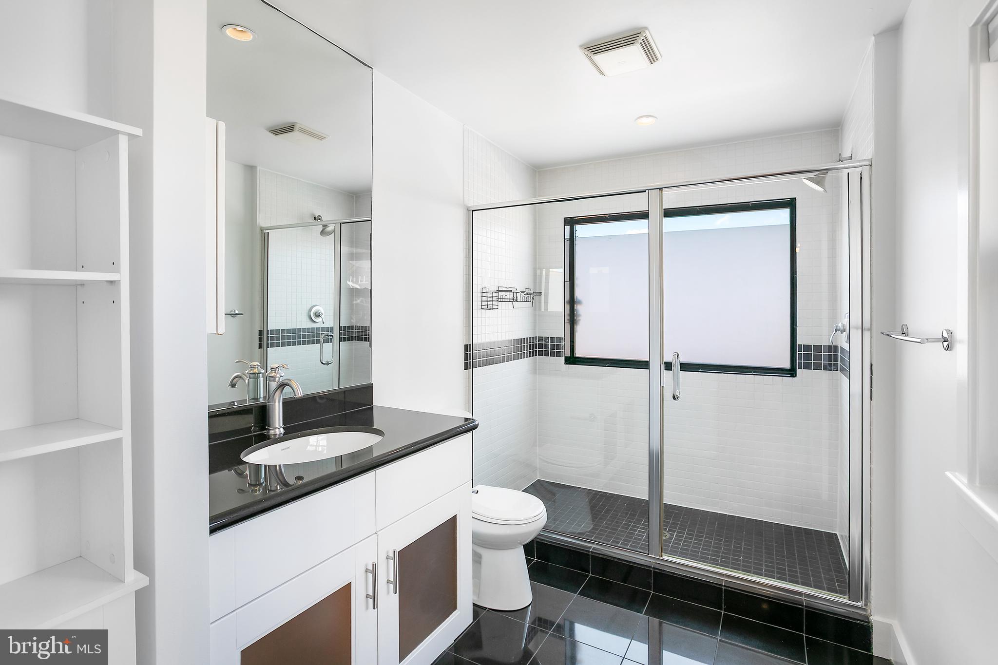 1461 Harvard Street Northwest, Unit 5 Washington, DC 20009 - Photo 22 of 33 a bathroom with a granite countertop sink toilet and shower