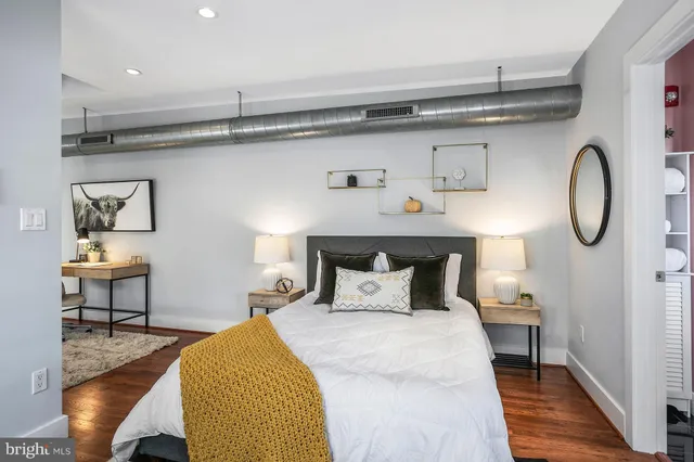 a bedroom with a bed and wooden floor
