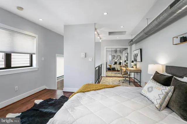 a bedroom with a bed and wooden floor