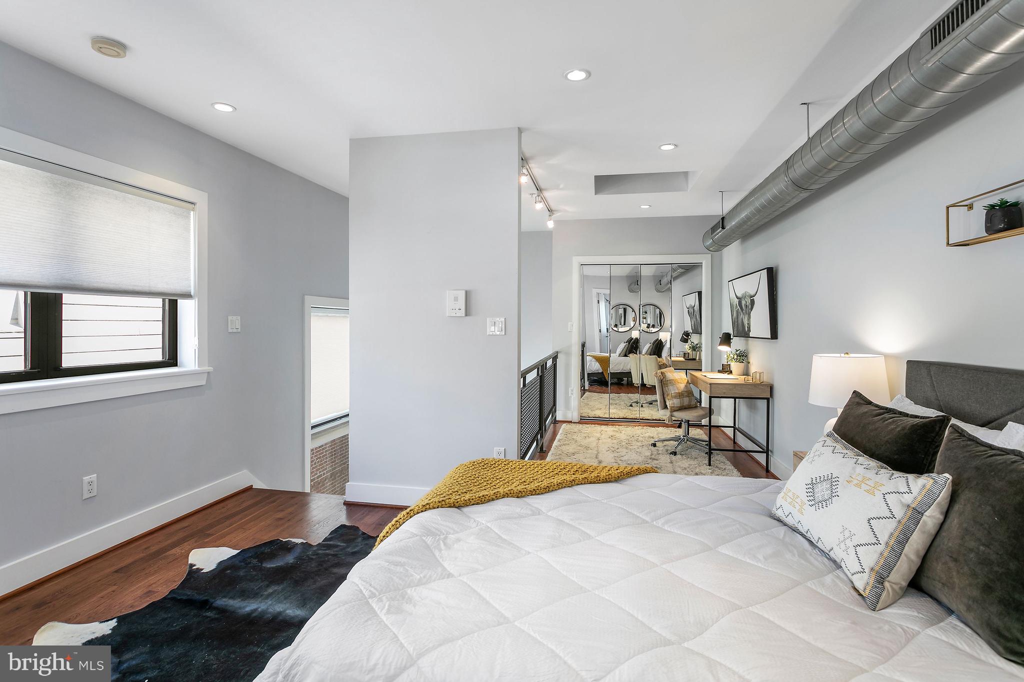 1461 Harvard Street Northwest, Unit 5 Washington, DC 20009 - Photo 24 of 33 a bedroom with a bed and wooden floor