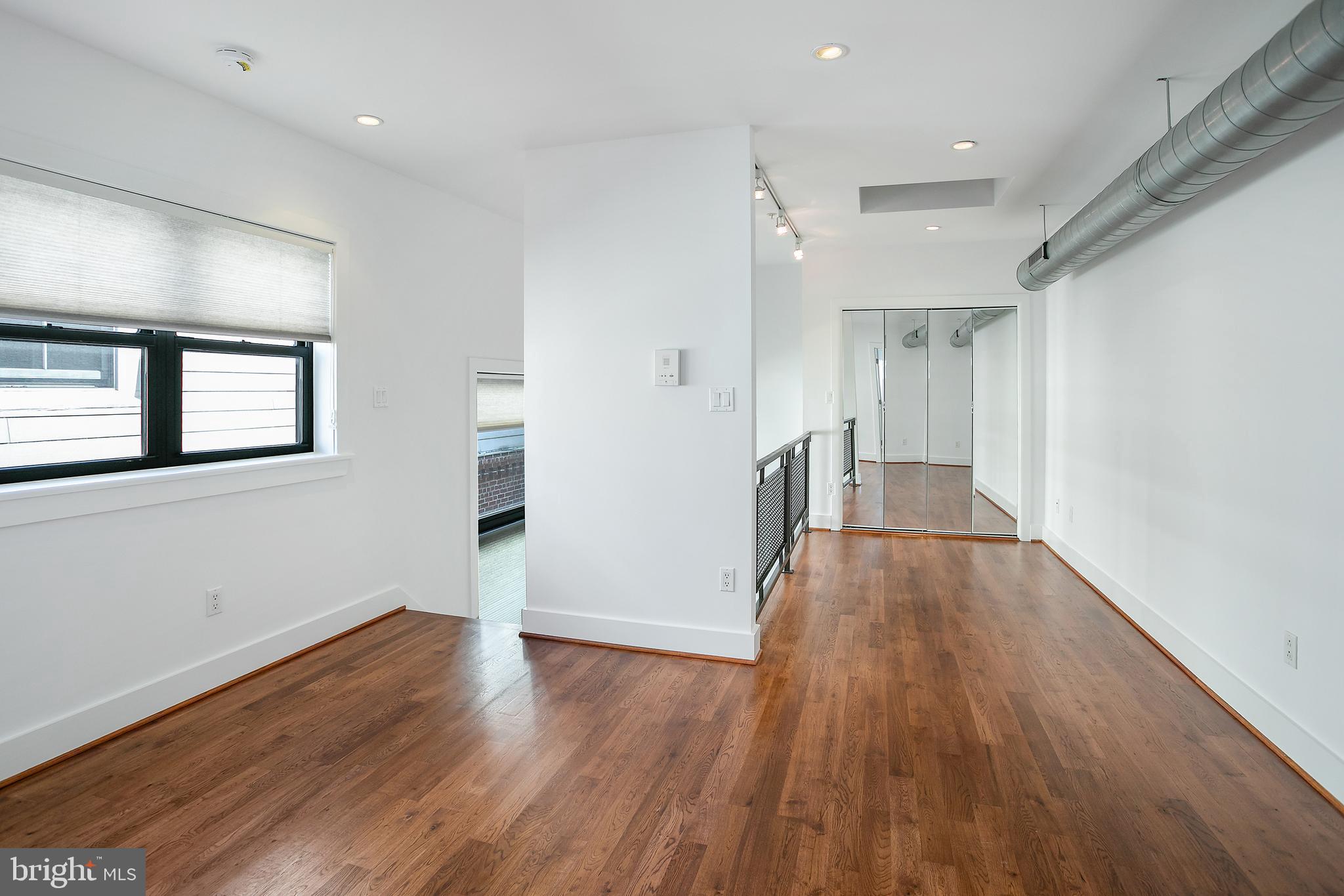 1461 Harvard Street Northwest, Unit 5 Washington, DC 20009 - Photo 25 of 33 wooden floor in an empty room with a window