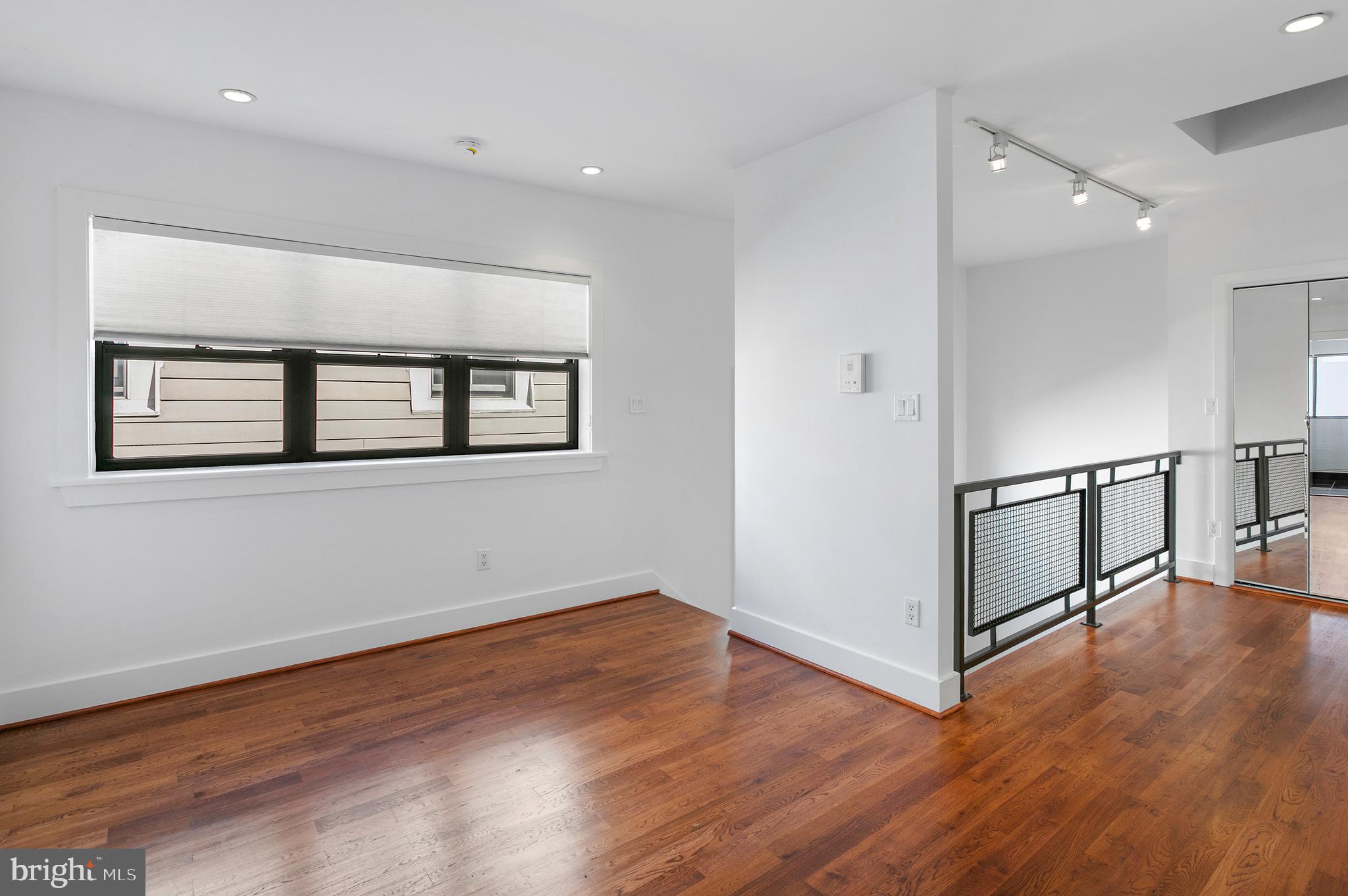 1461 Harvard Street Northwest, Unit 5 Washington, DC 20009 - Photo 26 of 33 an empty room with wooden floor and windows