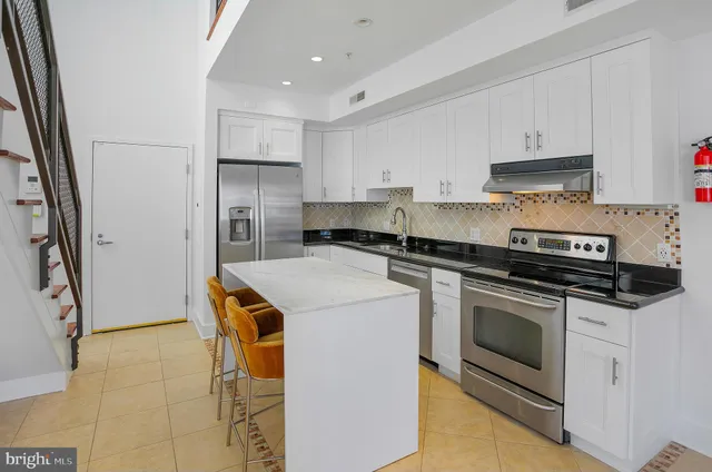 a kitchen with stainless steel appliances granite countertop a stove a refrigerator and a microwave