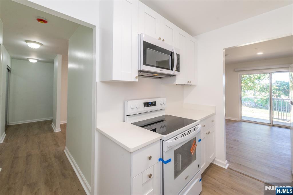 1111 River Road, Unit G5 Edgewater, NJ 07020 - Photo 5 of 20 a kitchen with stainless steel appliances granite countertop a stove and a microwave