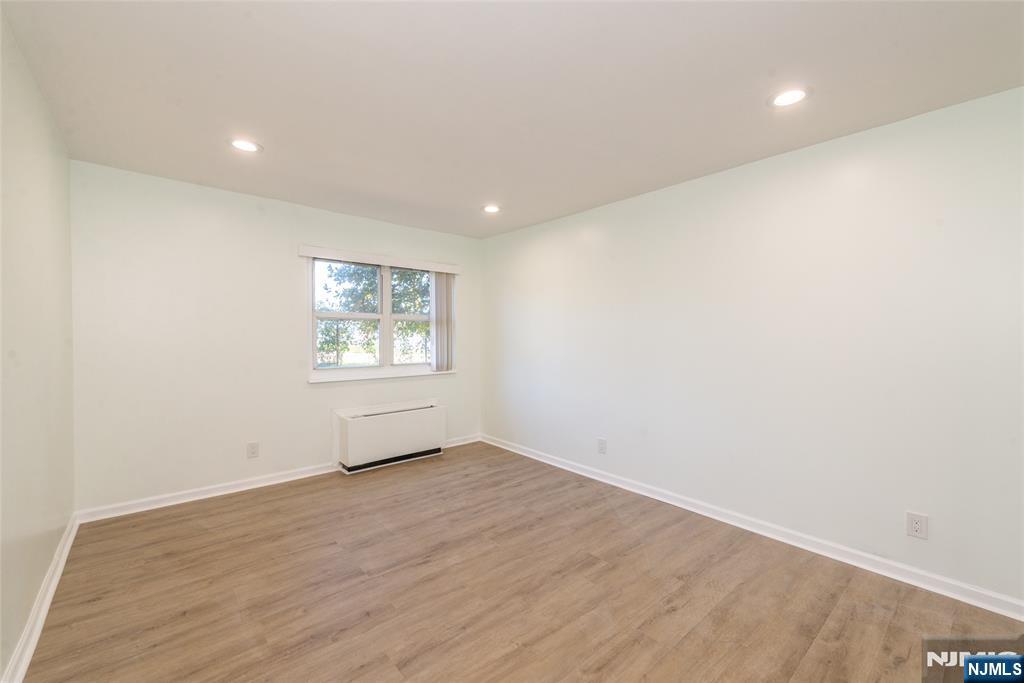 1111 River Road, Unit G5 Edgewater, NJ 07020 - Photo 9 of 20 an empty room with wooden floor and windows