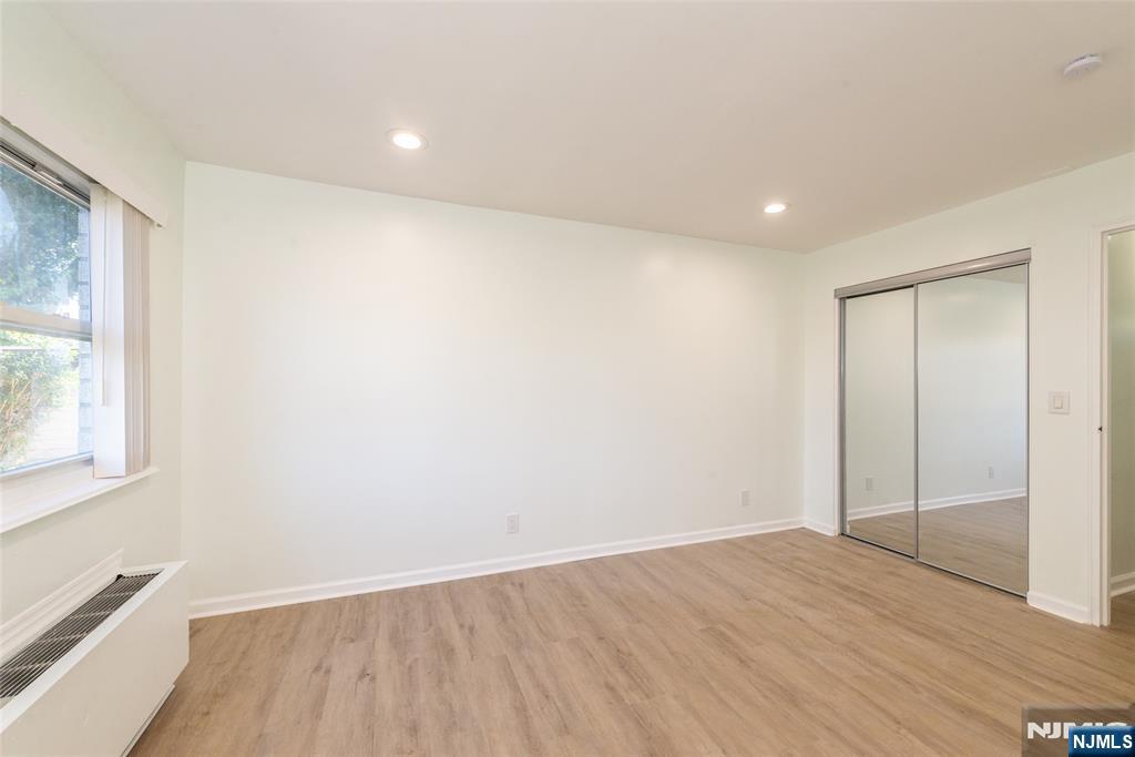 1111 River Road, Unit G5 Edgewater, NJ 07020 - Photo 10 of 20 an empty room with wooden floor and windows