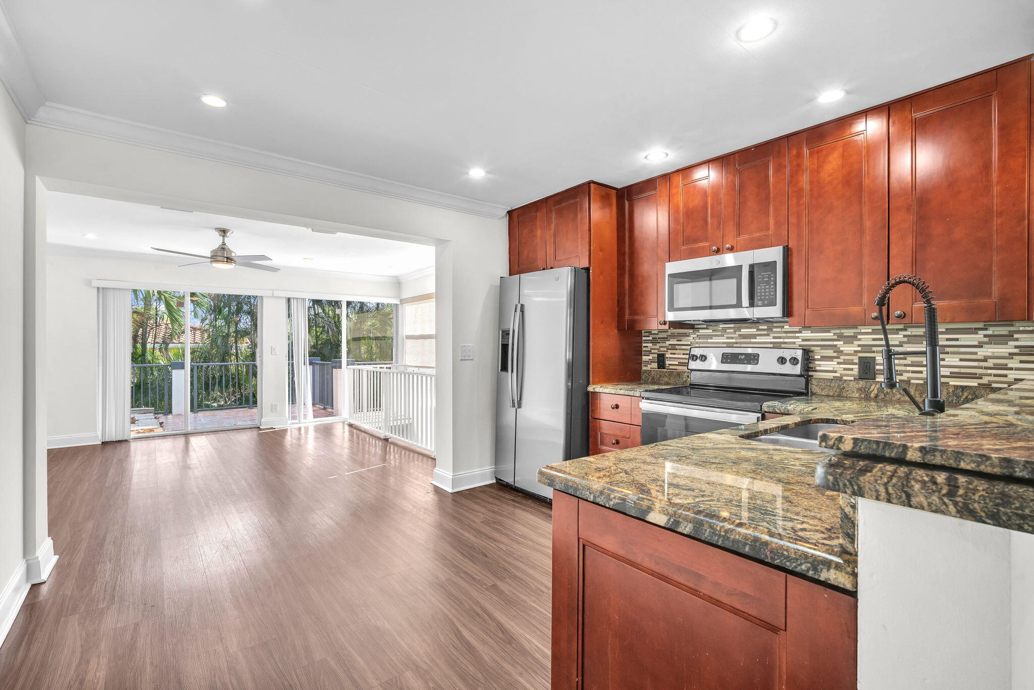 144 Northwest 4th Avenue Boca Raton, FL 33432 - Photo 11 of 35 a kitchen with stainless steel appliances granite countertop a refrigerator a sink dishwasher a stove and a wooden cabinets with wooden floor