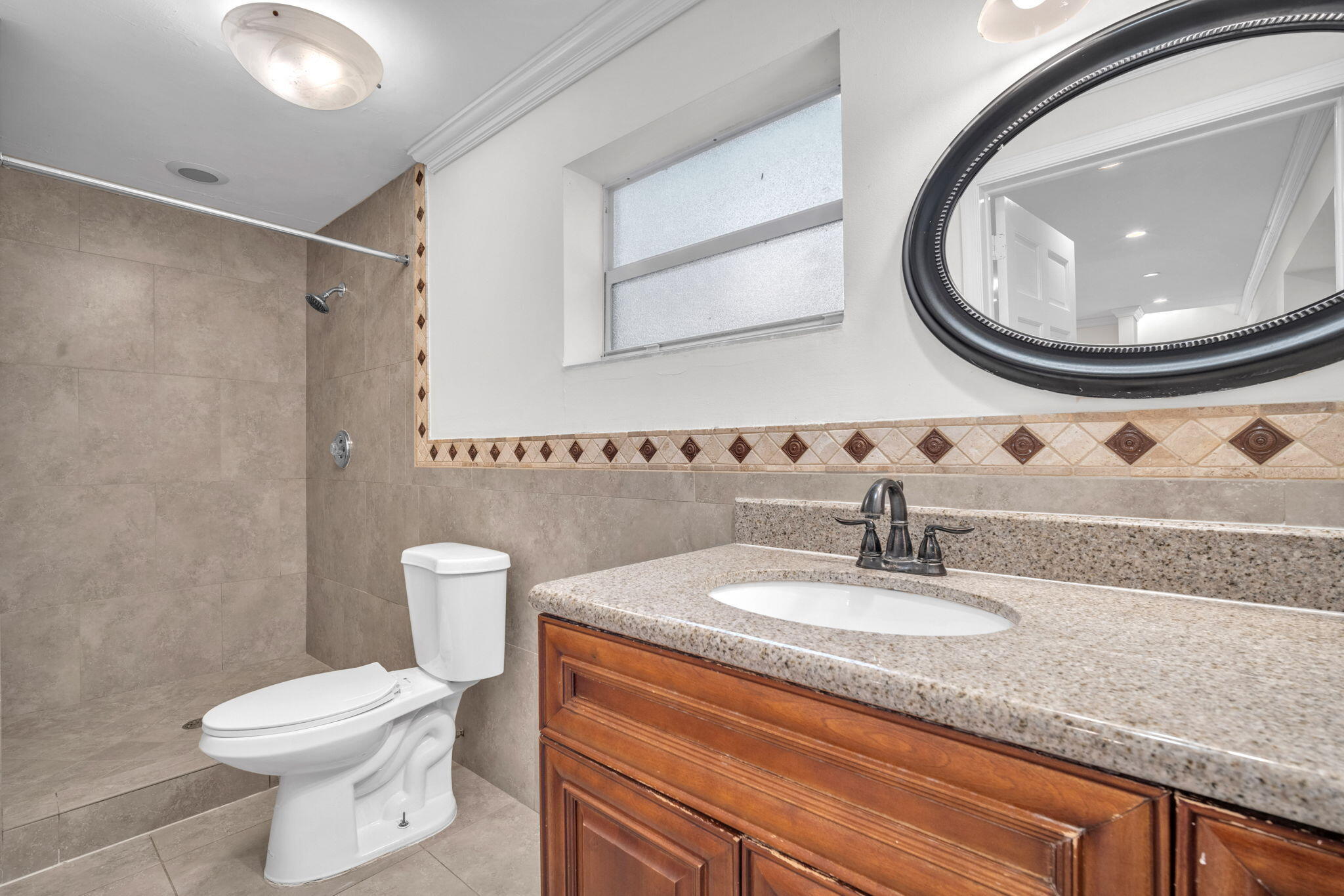 144 Northwest 4th Avenue Boca Raton, FL 33432 - Photo 22 of 35 a bathroom with a granite countertop toilet sink and mirror