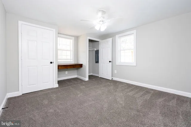 an empty room with windows and closet