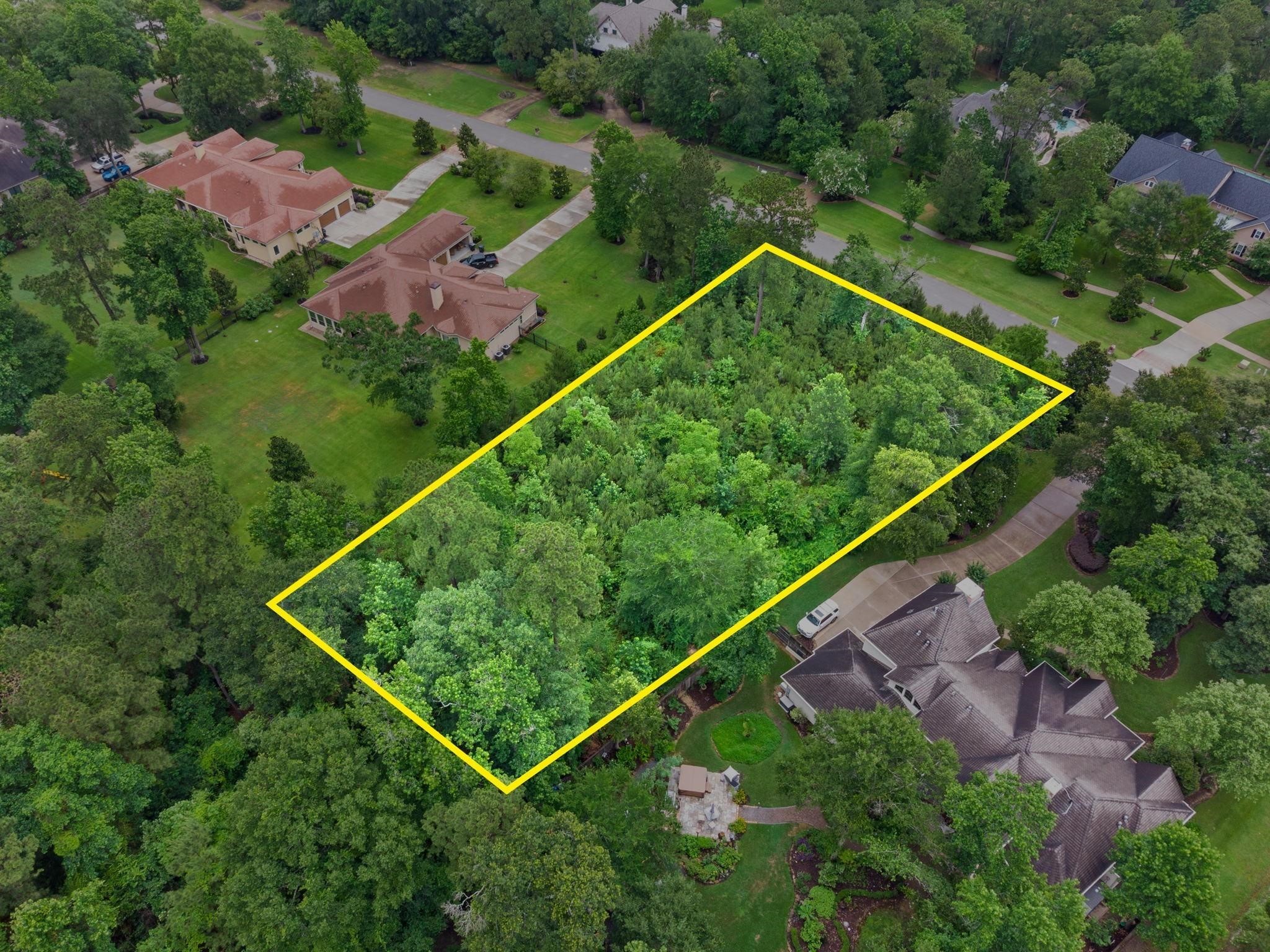 27403 Whispering Maple Way Spring, TX 77386 - Photo 7 of 10 This aerial photo showcases a spacious, tree-filled lot outlined in yellow, nestled in a serene, residential neighborhood with nearby homes. Ideal for those seeking privacy and natural surroundings.