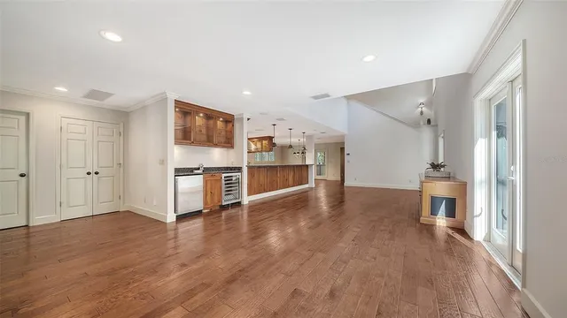 a view of a kitchen with kitchen island a sink wooden floor and living room