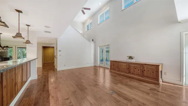 a large kitchen with stainless steel appliances kitchen island granite countertop a stove a sink a refrigerator and blue cabinets with wooden floor