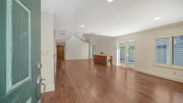 a view of a kitchen with kitchen island a sink wooden floor and stainless steel appliances