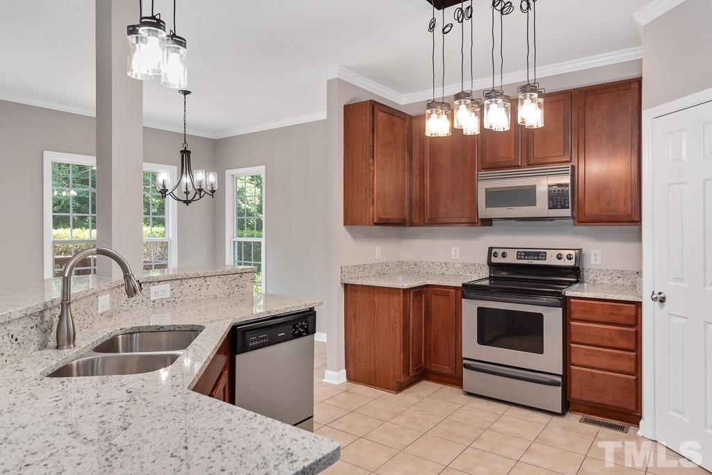618 Red Cedar Circle Durham, NC 27712 - Photo 19 of 45 a kitchen with stainless steel appliances granite countertop a stove and a sink