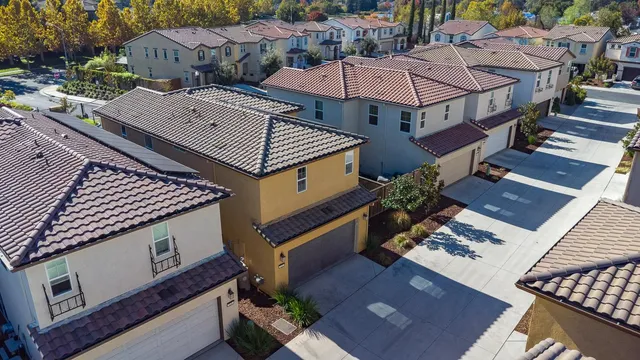 a front view of a residential apartment building with a yard and parking space