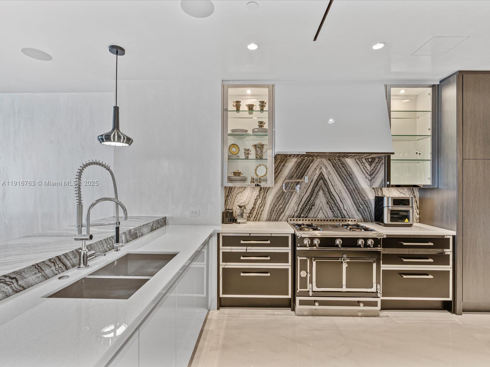 17901 Collins Avenue, Unit 2602 Sunny Isles Beach, FL 33160 - Photo 13 of 85 a kitchen with a stove and a sink