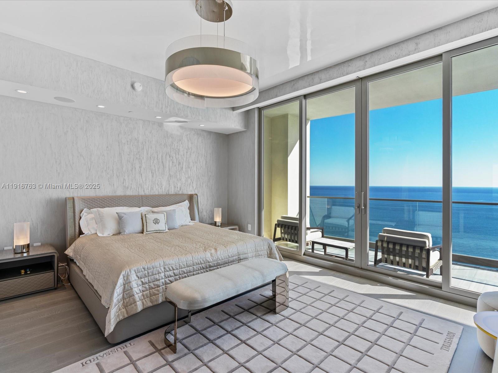 17901 Collins Avenue, Unit 2602 Sunny Isles Beach, FL 33160 - Photo 18 of 85 a bedroom with a large bed and a chandelier