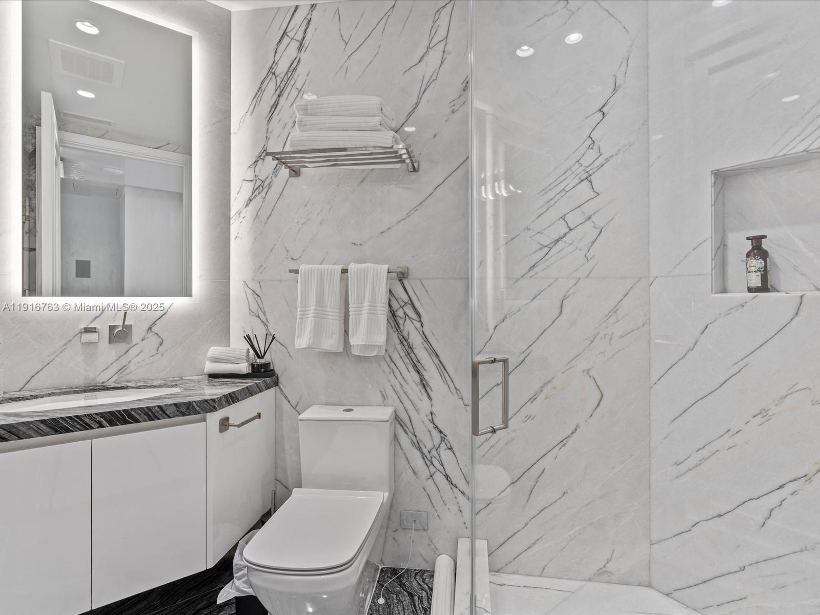 17901 Collins Avenue, Unit 2602 Sunny Isles Beach, FL 33160 - Photo 39 of 85 a white toilet sitting next to a bathroom sink