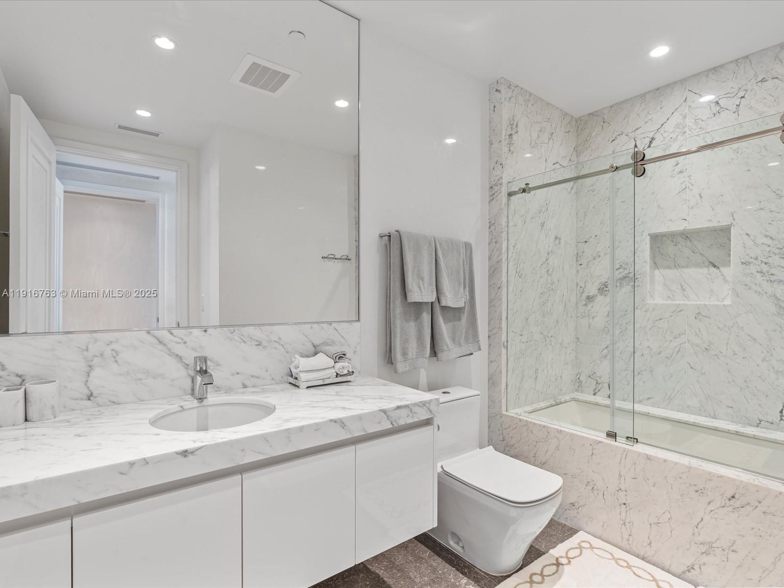 17901 Collins Avenue, Unit 2602 Sunny Isles Beach, FL 33160 - Photo 45 of 85 a bathroom with a sink toilet a mirror and shower