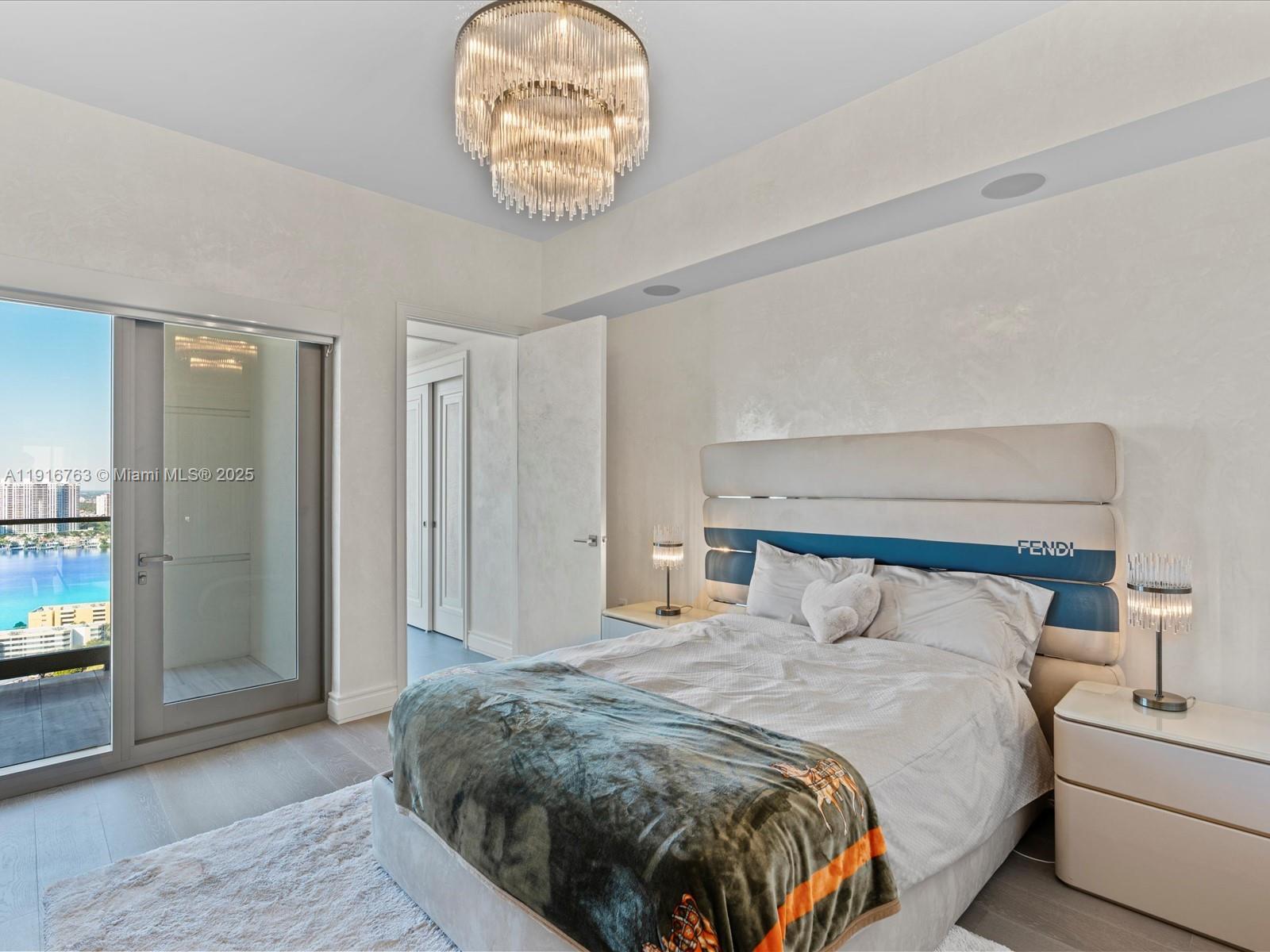 17901 Collins Avenue, Unit 2602 Sunny Isles Beach, FL 33160 - Photo 47 of 85 a bedroom with a bed and a chandelier