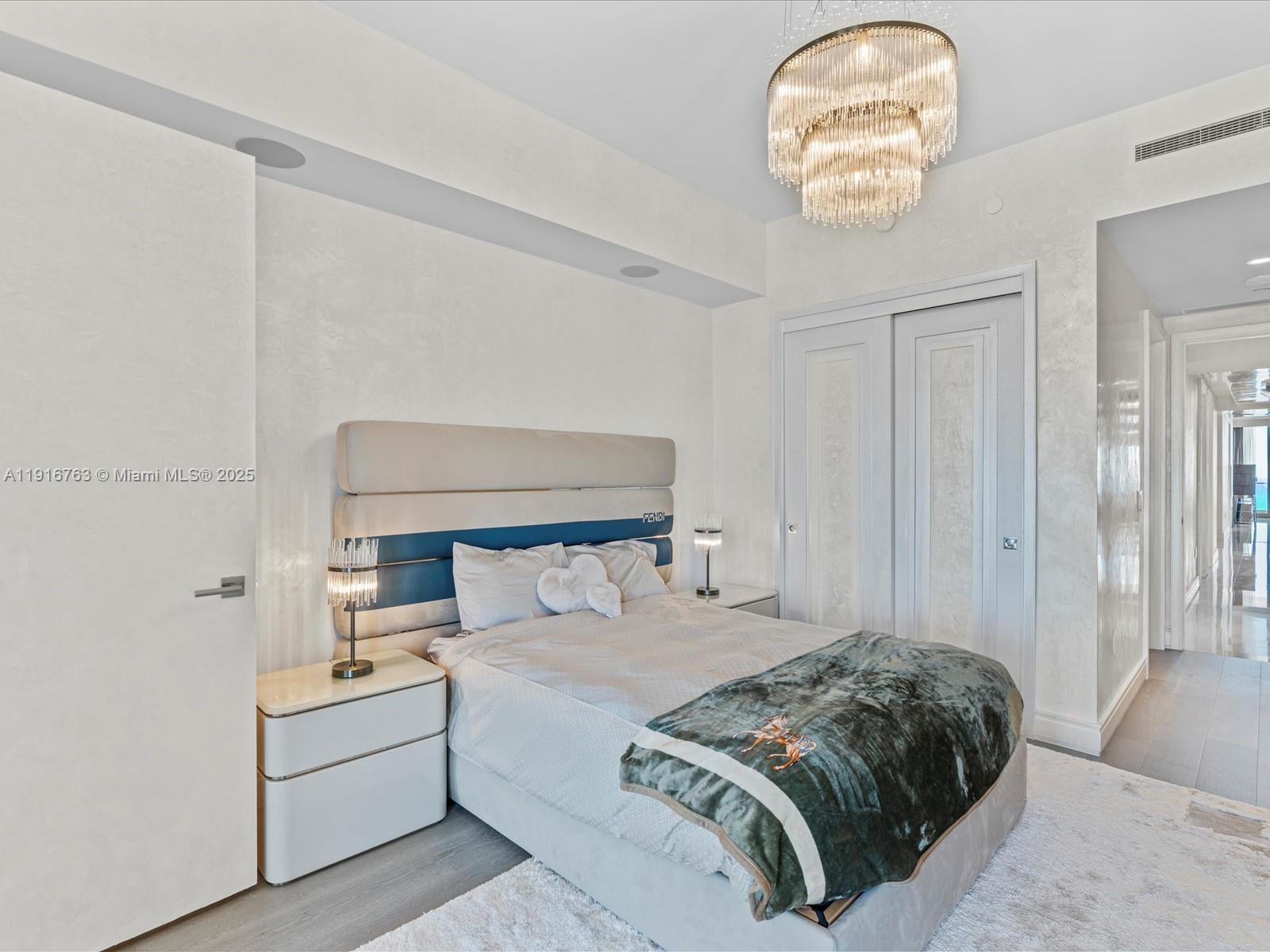 17901 Collins Avenue, Unit 2602 Sunny Isles Beach, FL 33160 - Photo 48 of 85 a bedroom with a large bed and a chandelier