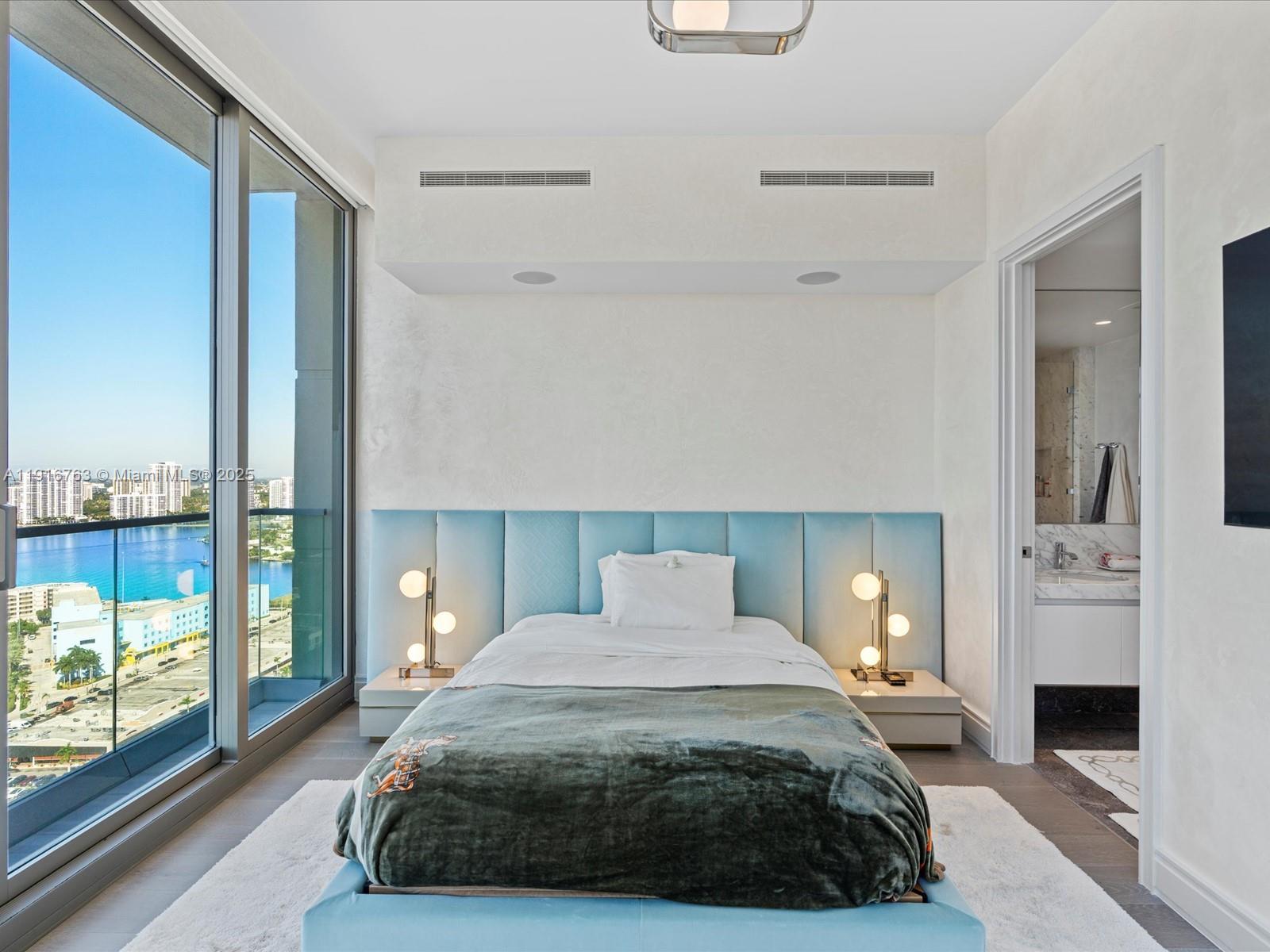 17901 Collins Avenue, Unit 2602 Sunny Isles Beach, FL 33160 - Photo 55 of 85 a bedroom with a large bed and a fireplace