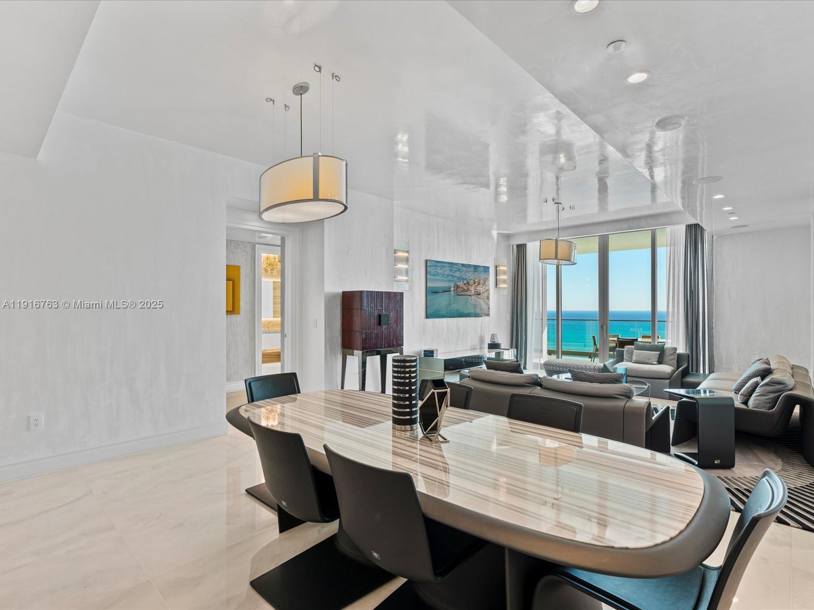 17901 Collins Avenue, Unit 2602 Sunny Isles Beach, FL 33160 - Photo 6 of 85 a dining room with furniture a large window and a chandelier