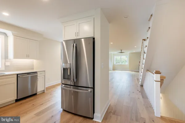 a kitchen with a refrigerator a stove top oven and wooden floor