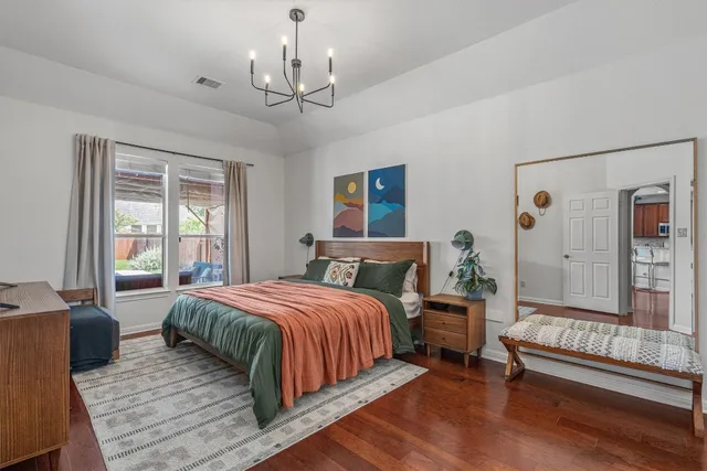 a bedroom with a large bed and a chandelier