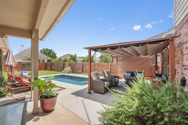 a view of a patio with a dining table and chairs potted plants