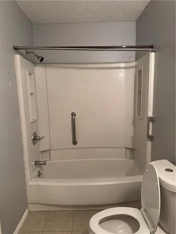 a bathroom with a shower a bathtub and a toilet