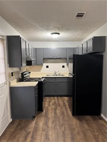 a kitchen with stainless steel appliances a refrigerator sink and cabinets