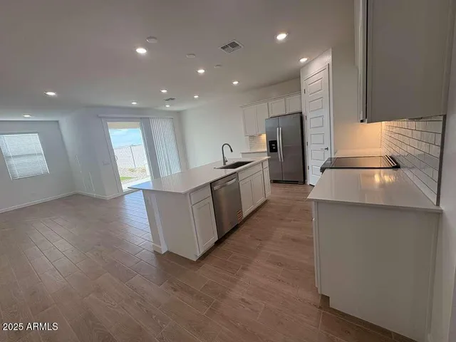 a kitchen with refrigerator and cabinets