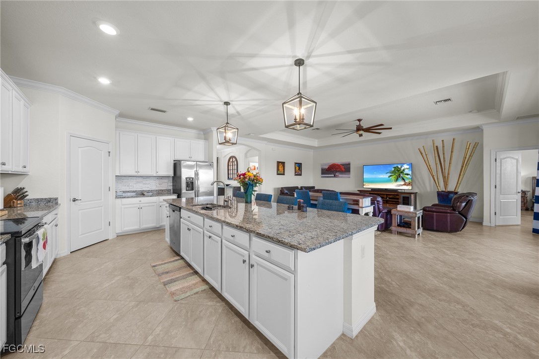 10061 Avalon Lake Circle, Unit 104 Fort Myers, FL 33913 - Photo 14 of 46 a large kitchen with kitchen island a large counter space a sink stainless steel appliances and cabinets