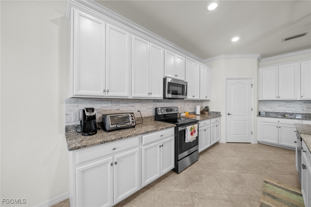 10061 Avalon Lake Circle, Unit 104 Fort Myers, FL 33913 - Photo 15 of 46 a kitchen with granite countertop white cabinets stainless steel appliances and a sink
