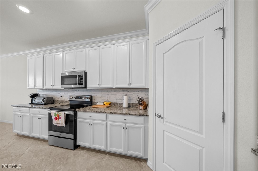 10061 Avalon Lake Circle, Unit 104 Fort Myers, FL 33913 - Photo 17 of 46 a kitchen with white cabinets and white appliances