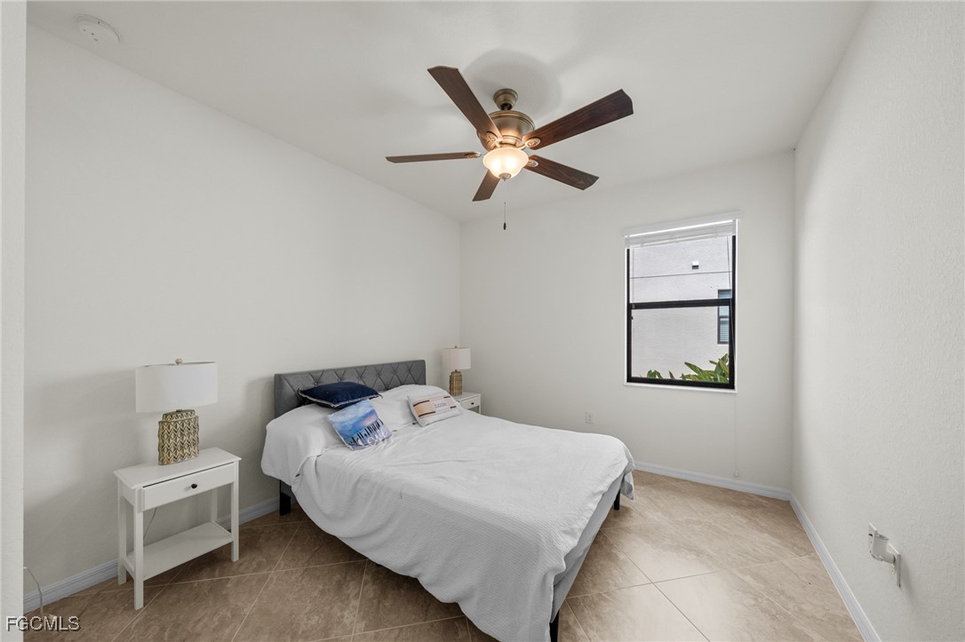 10061 Avalon Lake Circle, Unit 104 Fort Myers, FL 33913 - Photo 25 of 46 a bedroom with a bed and a window