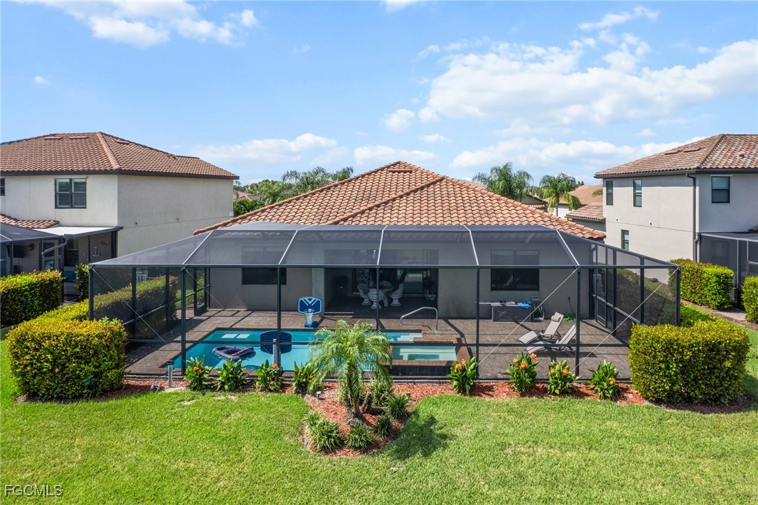 10061 Avalon Lake Circle, Unit 104 Fort Myers, FL 33913 - Photo 45 of 46 a view of a patio with table and chairs under an umbrella