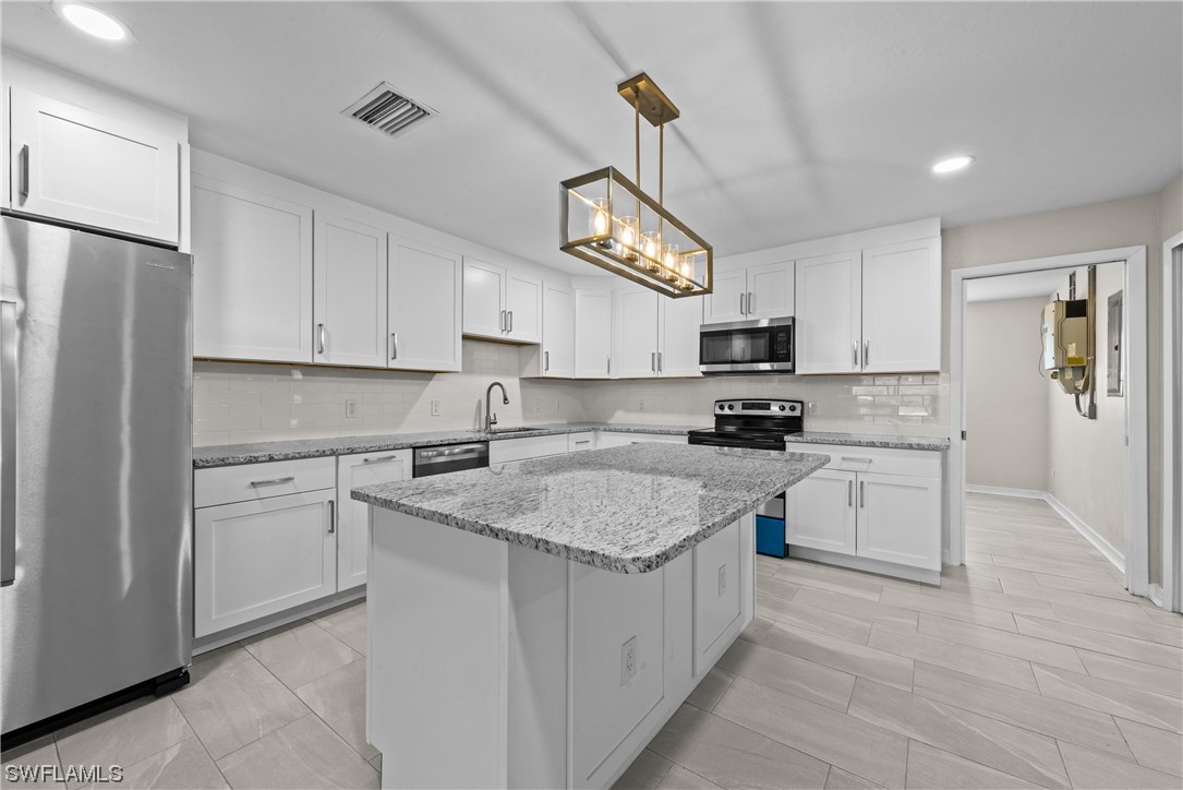 1058 Old Bridge Road North Fort Myers, FL 33917 - Photo 11 of 43 a kitchen with stainless steel appliances granite countertop a refrigerator stove microwave and cabinets