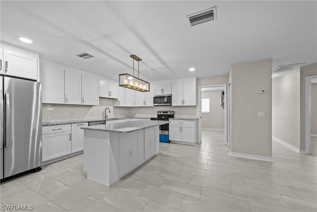 1058 Old Bridge Road North Fort Myers, FL 33917 - Photo 12 of 43 a kitchen with kitchen island a sink stainless steel appliances and cabinets