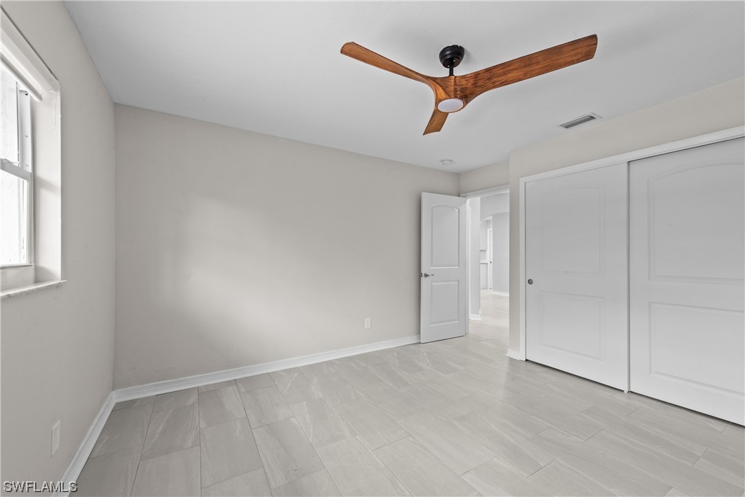 1058 Old Bridge Road North Fort Myers, FL 33917 - Photo 17 of 43 an empty room with ceiling fan and window