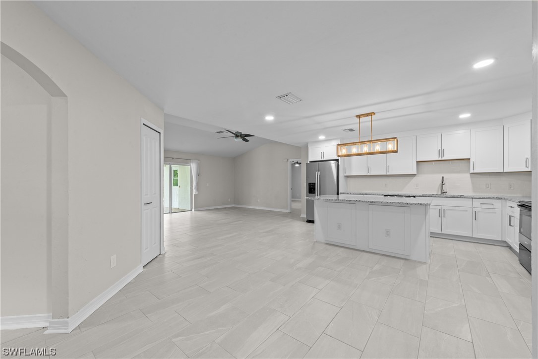 1058 Old Bridge Road North Fort Myers, FL 33917 - Photo 7 of 43 a large white kitchen with stainless steel appliances granite countertop a sink and cabinets