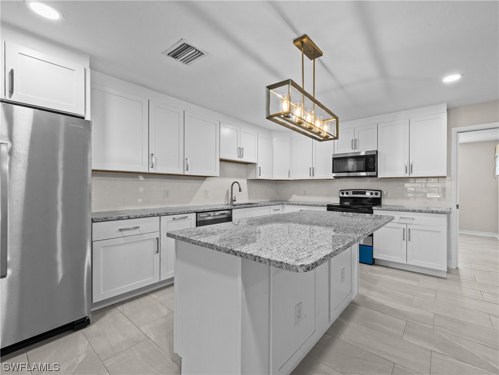 1058 Old Bridge Road North Fort Myers, FL 33917 - Photo 9 of 43 a kitchen with stainless steel appliances granite countertop a refrigerator a stove top oven a sink and dishwasher