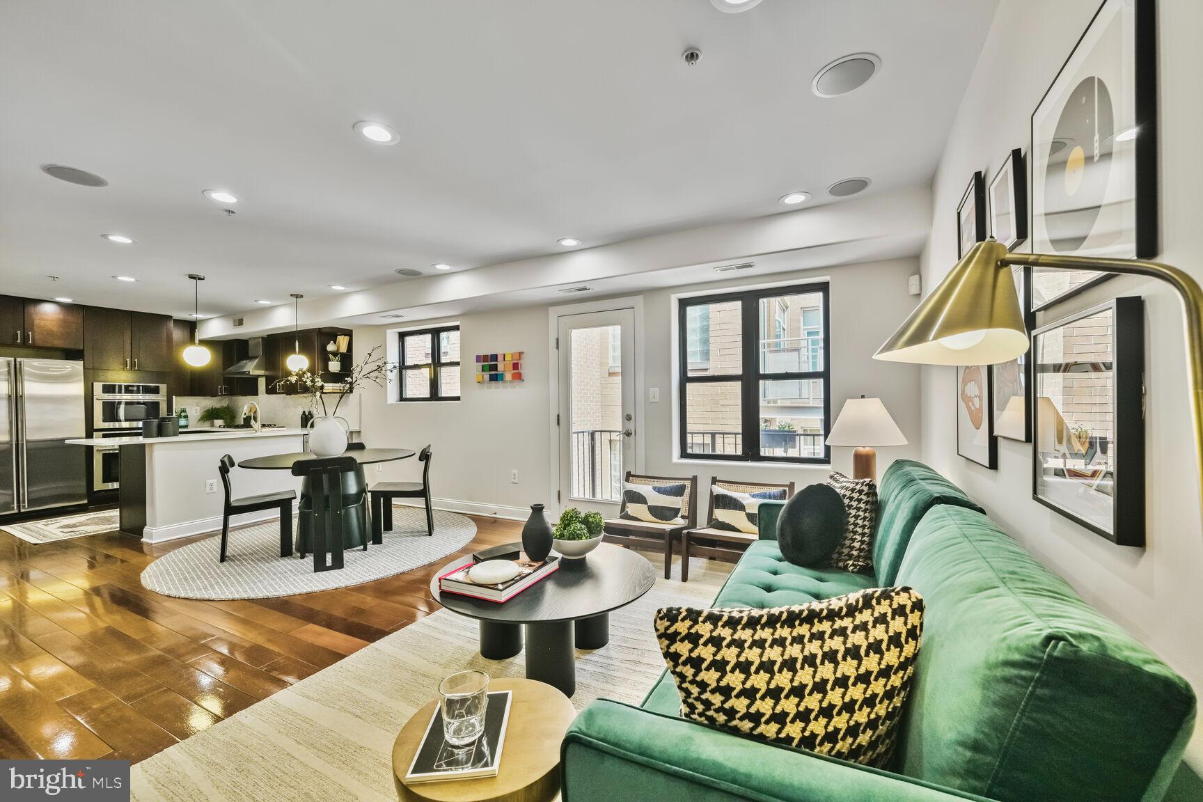 a living room with furniture kitchen view and a large window