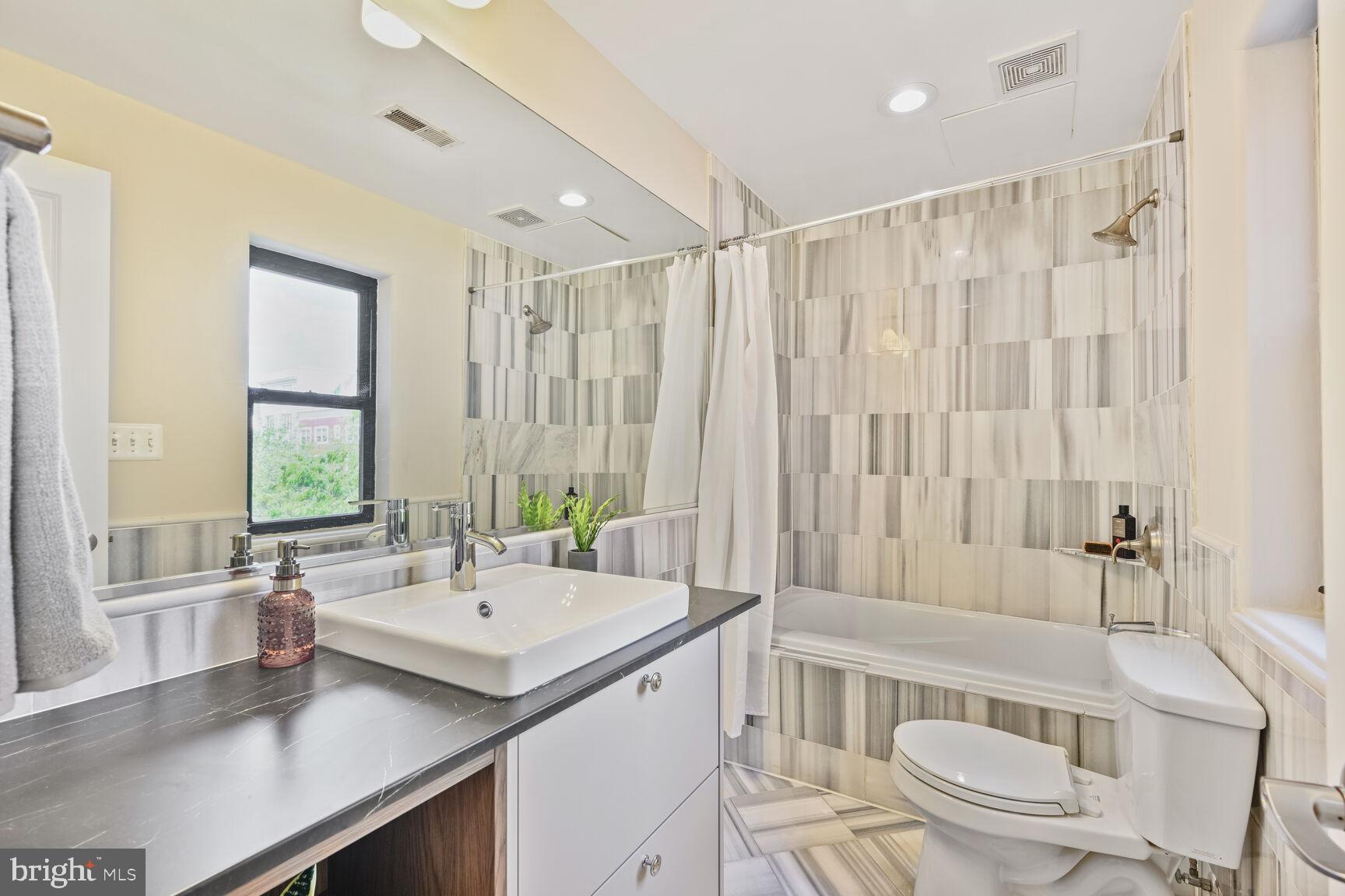1354 Euclid Street Northwest, Unit 403A Washington, DC 20009 - Photo 13 of 26 a bathroom with a granite countertop sink toilet and shower