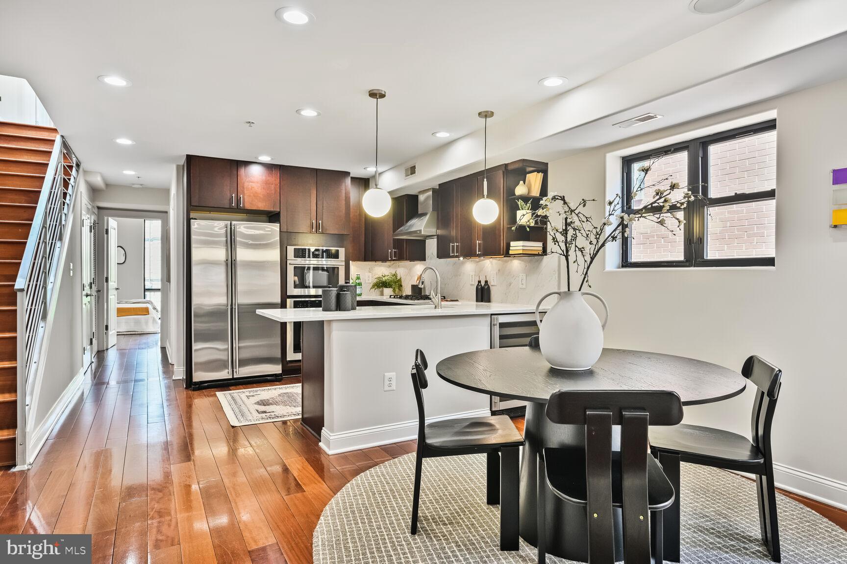 1354 Euclid Street Northwest, Unit 403A Washington, DC 20009 - Photo 4 of 26 a kitchen with a table chairs refrigerator and microwave