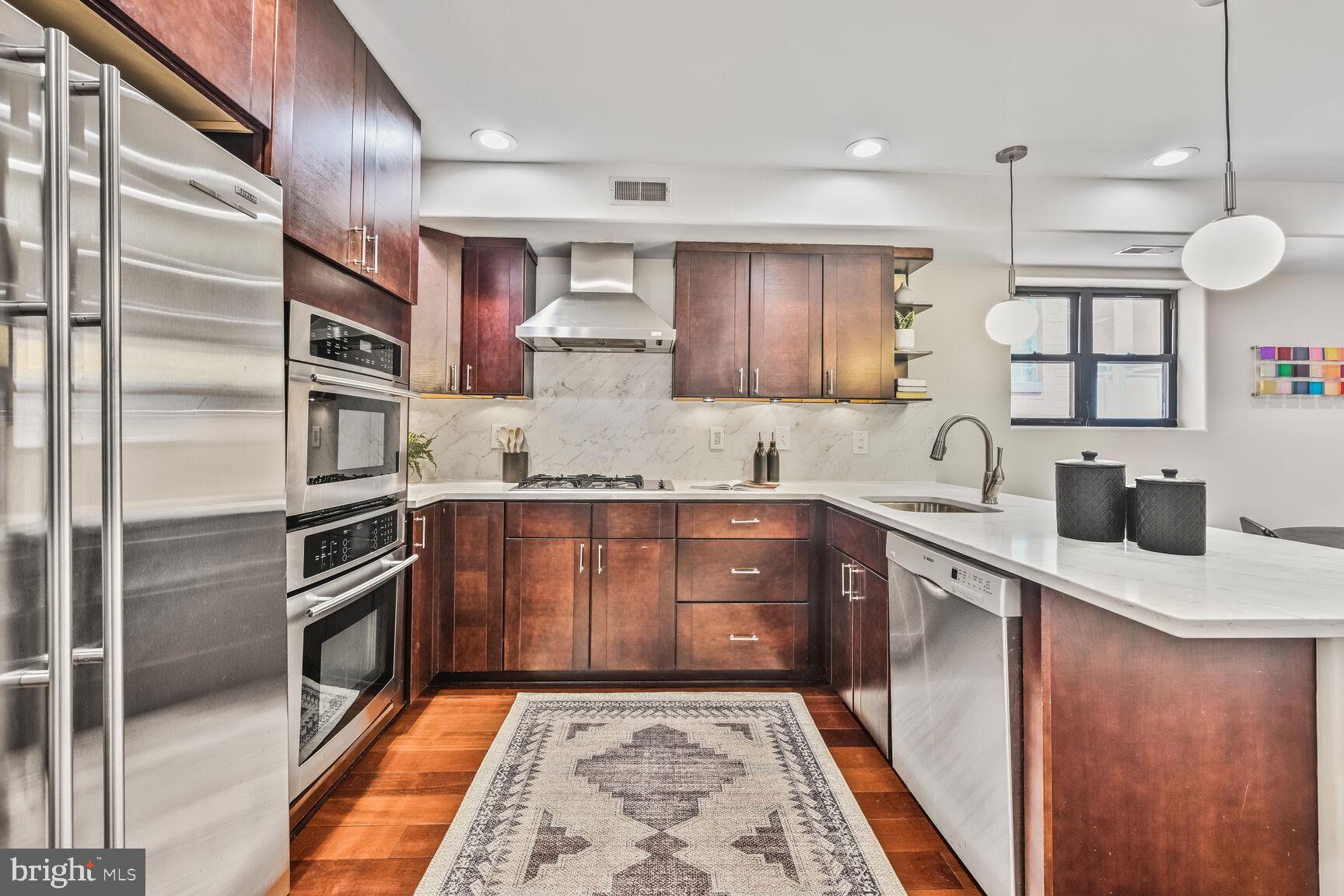 1354 Euclid Street Northwest, Unit 403A Washington, DC 20009 - Photo 8 of 26 a kitchen with stainless steel appliances granite countertop a sink and a stove